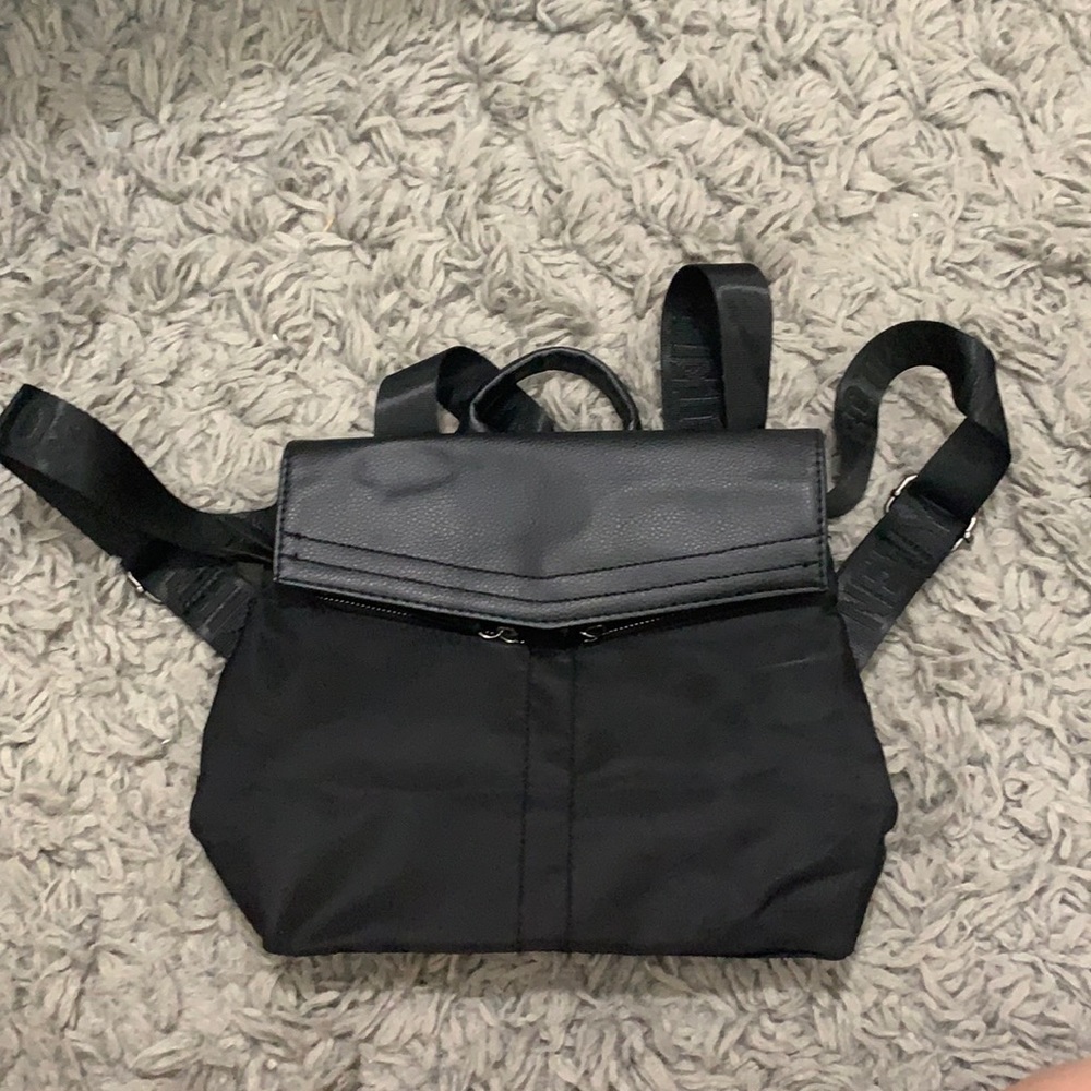 Black mini backpack/bag and a magnet button to close with zippers